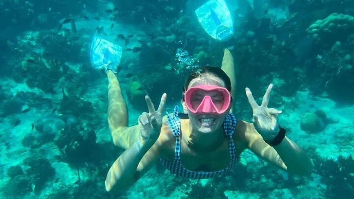 Snorkelers entering clear turquoise water from a small boat on a Catalina Island snorkeling tour off Isla Catalina, Dominican Republic